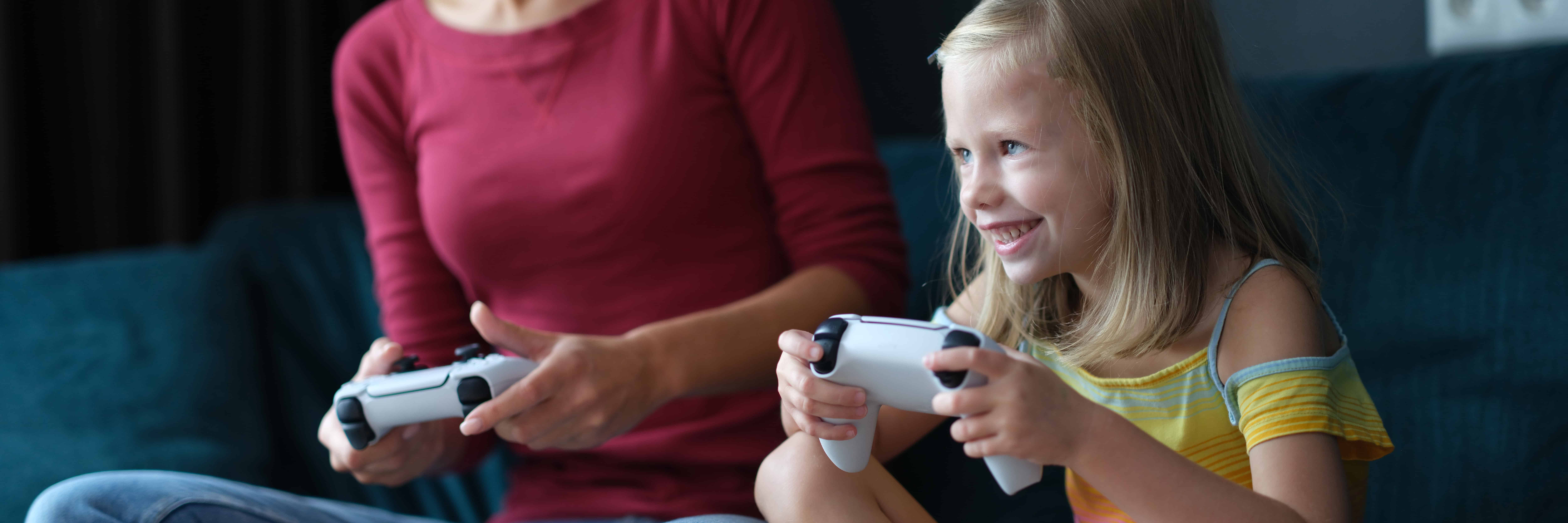 44490844 mom and daughter play online games on console closeup
